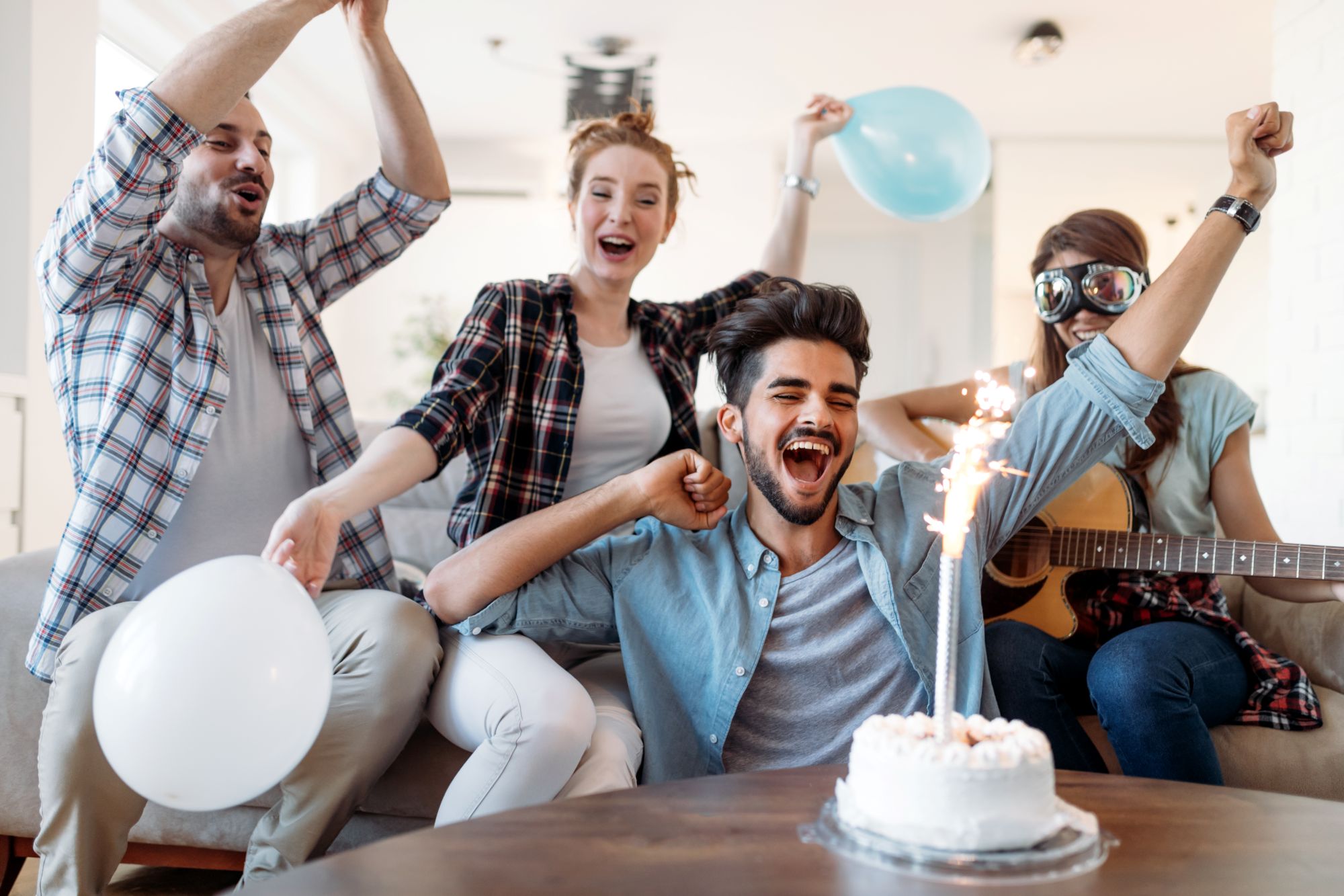 Phone playing a personalised AI happy birthday song surrounded by candles and balloons