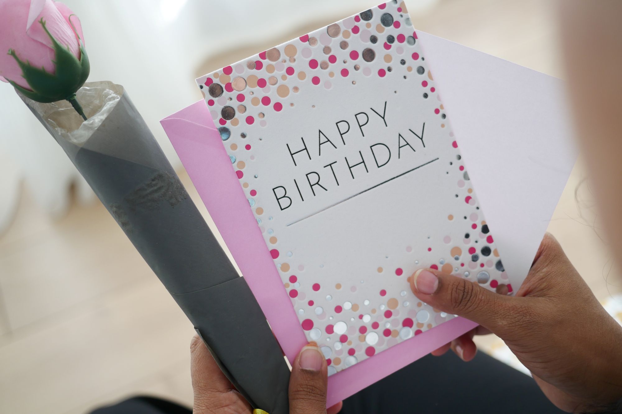 Recordable birthday greeting card on a wooden table with envelope and confetti