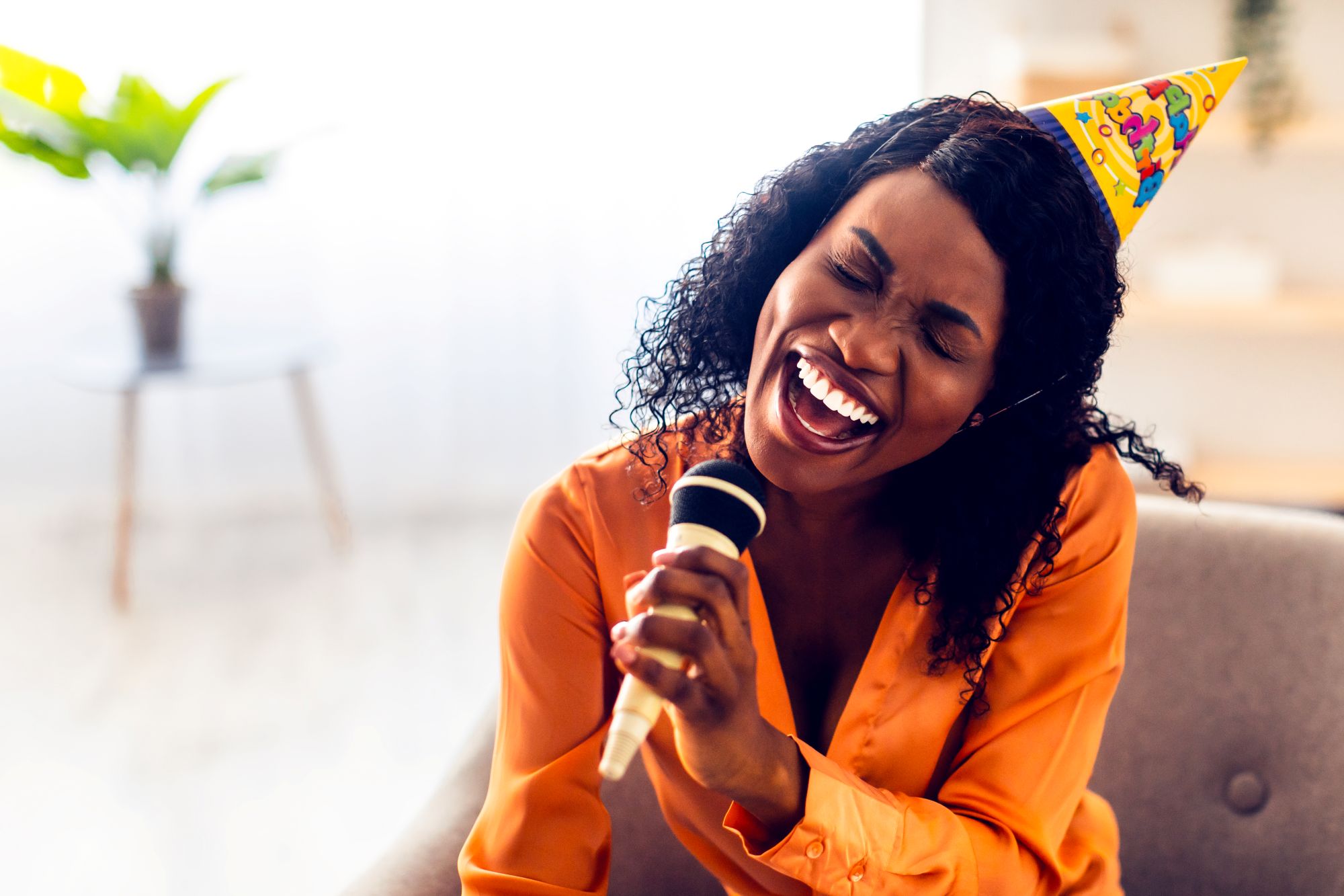 Birthday person laughing while listening to their custom AI birthday song with friends